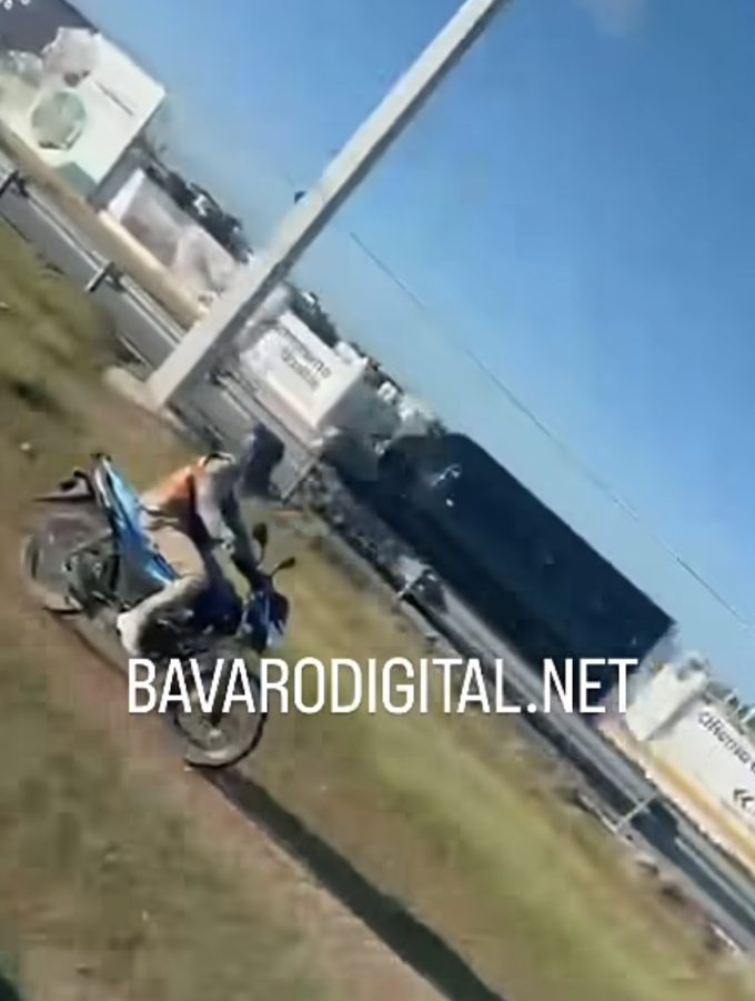 Graban motorista conduciendo entre postes de luz en el Boulevard Turístico del Este